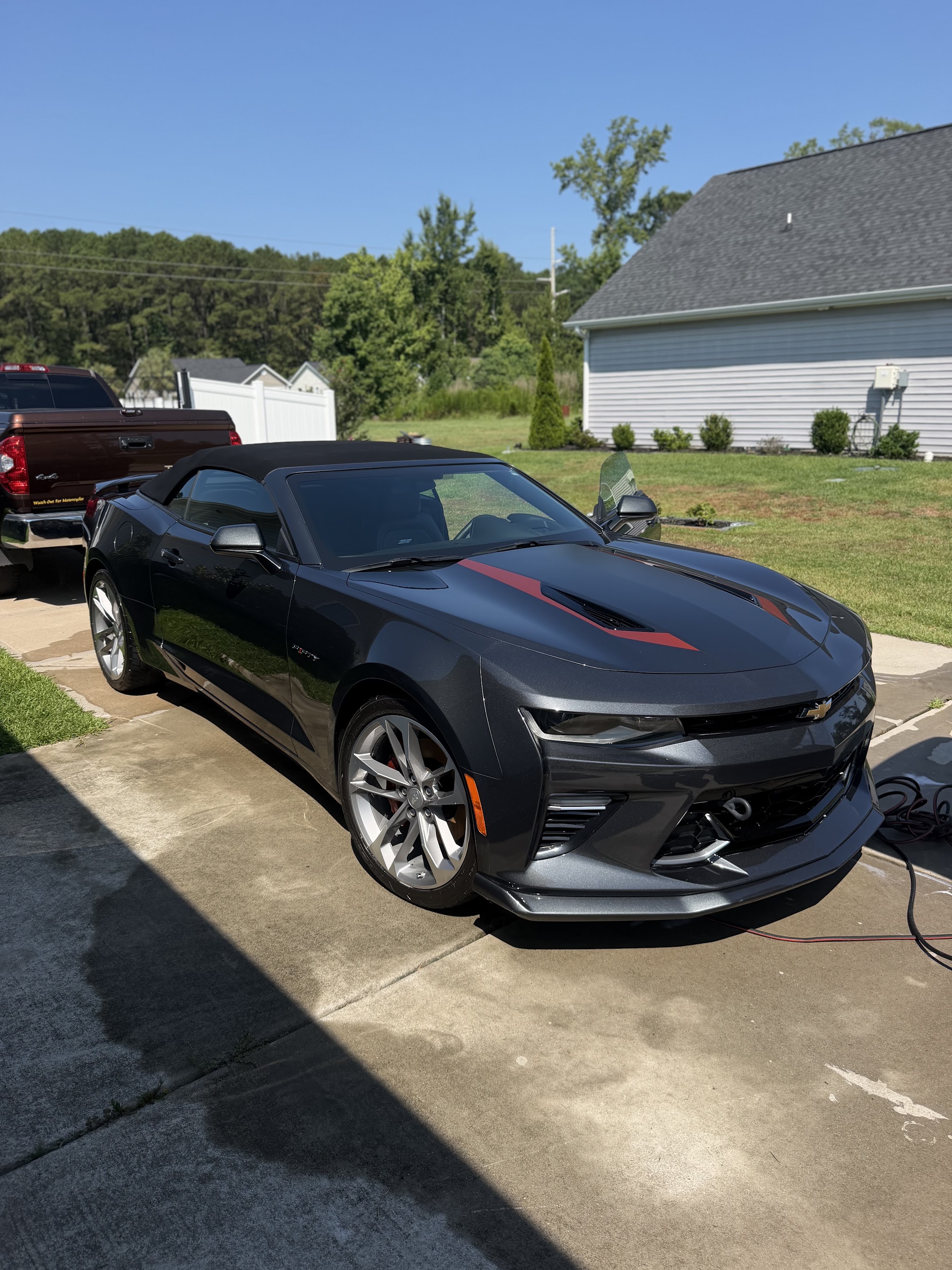 Black Camaro convertible with red stripes after a detail