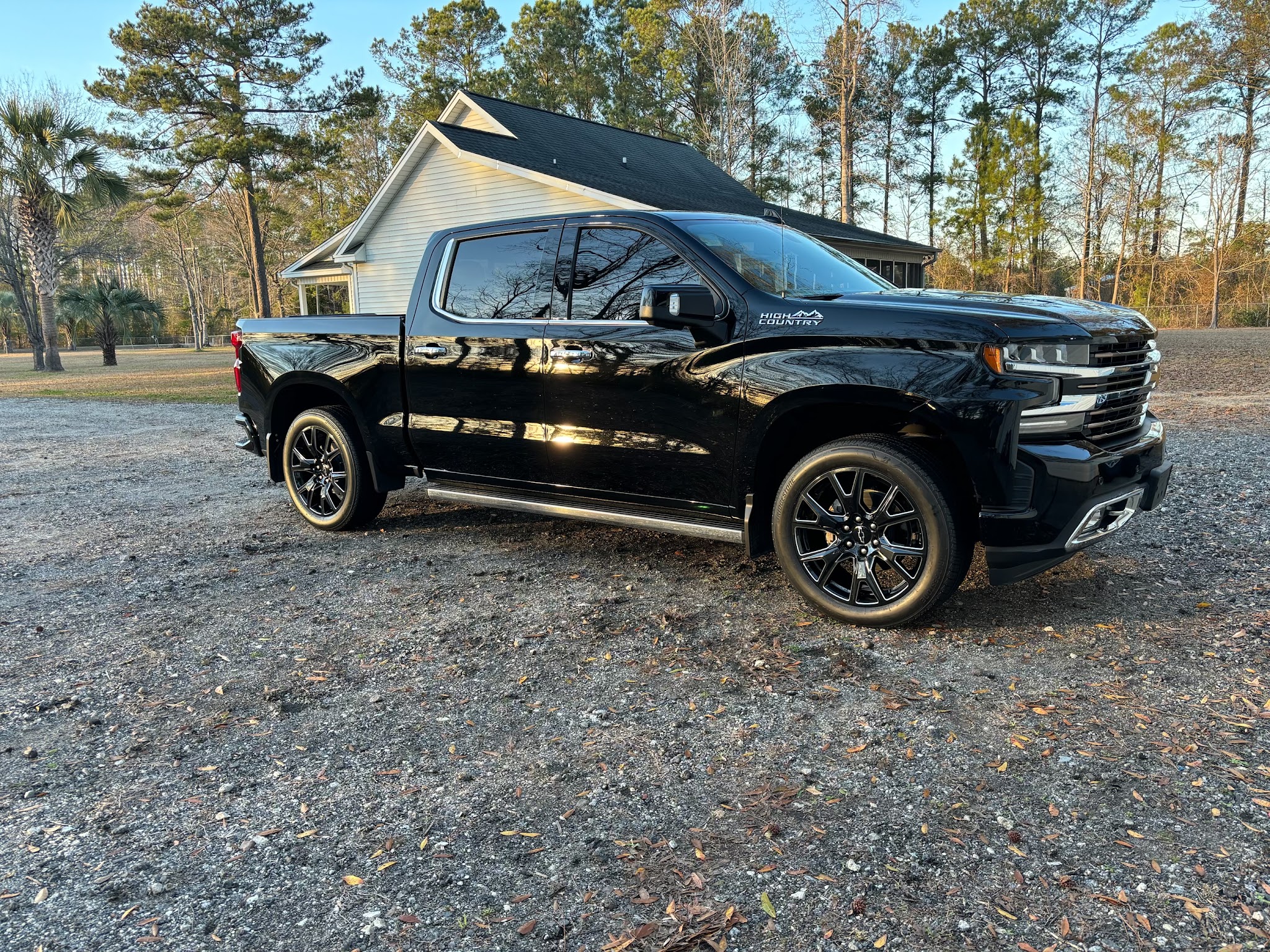 Black pickup on a gravel drive